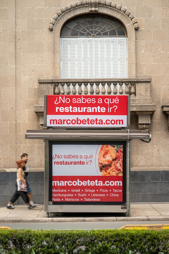 Urban street scene featuring a restaurant advertisement on a building in Mexico City.