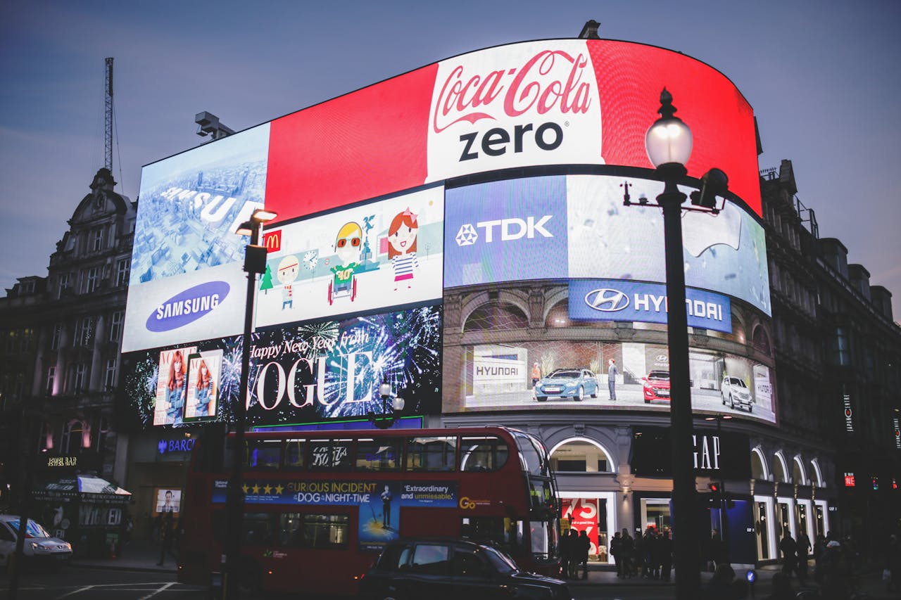 services-03 Night view of Piccadilly Circus in London with bright billboards and a red double-decker bus.
